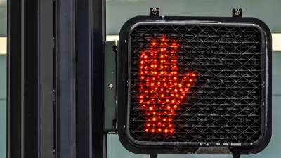Red hand lit up as "don't walk" pedestrian signal.