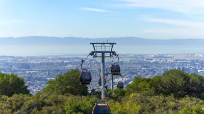View of aerial tram cars at Oakland Zoo with Oakland, California neighborhoods in background.