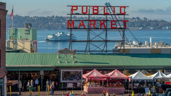 Public Market sign over Pike Place Market in Seattle, Washington with pop-up booths on street.
