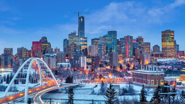 Dusk view of downtown Edmonton, Canada skyline with arched white bridge in foreground
