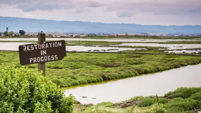 "Restoration in progress" sign in the wetlands in Alviso Marsh, Don Edwards wildlife refuge, south San Francisco Bay, California.