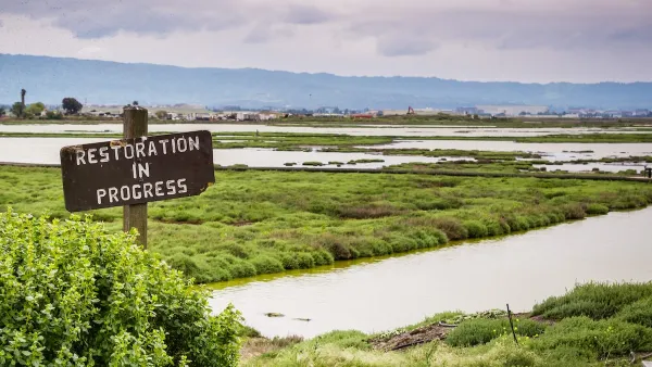 "Restoration in progress" sign in the wetlands in Alviso Marsh, Don Edwards wildlife refuge, south San Francisco Bay, California.