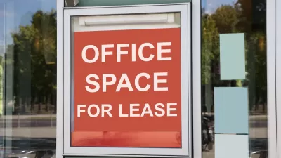 Close-up on red and white "Office space for lease" sign in window of office building.
