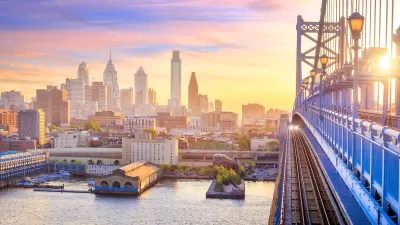 Phialdelphia skyline at sunset with close-up of bridge in foreground.
