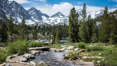 Small mountain lake with snow-capped mountains in background in Eastern Sierra Nevada mountains in California.