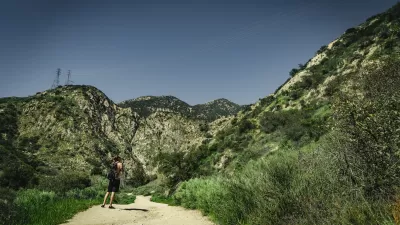 Lone hiker on gravel trail at Eaton Canyon Natural Area, Los Angeles County