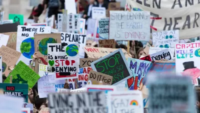 Close-up on dozens of anti-climate change signs at protest with people not visible.
