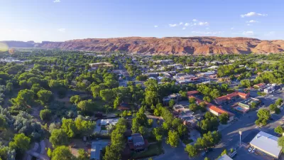 Aerial view of Moab, Utah with red mountains in background.