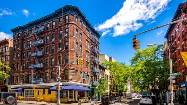 Mid-rise brick buildings with retail and restaurants on ground floor on sunny day in Soho, Manhattan, New York City.