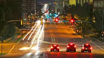 Three cars stopped at a traffic light in downtown Salt Lake City, Utah at night.