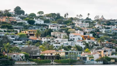 Dense neighborhood of homes on a hillside on the water in San Diego, California.