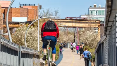 People on bikes and walking on 606 Bloomingdale Bike Trail on sunny day in Chicago, Illinois.
