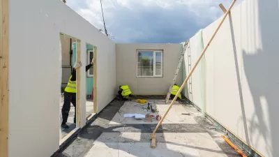 Workers assembling a modular housing unit.