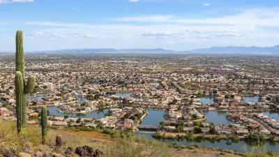 View from hilltop of Glendale, Arizona with saguaro cactus in left foreground.