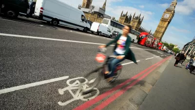 Blurry person in bike riding quickly in bike lane with Big Ben in background in London, UK.