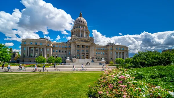 Group of bikes riding in front of Idaho State Capitol dome.