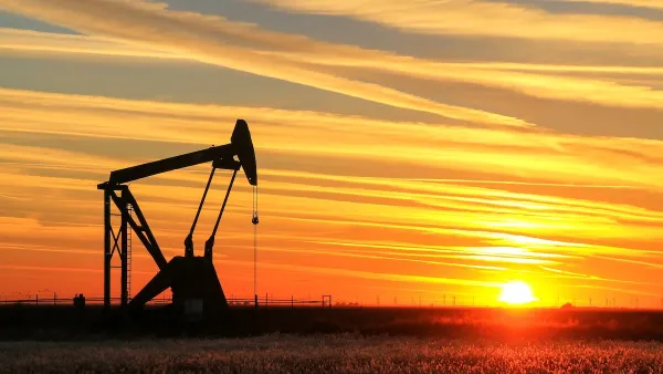 Oil pumpjack in a field at sunset.