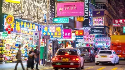 Cars and pedestrians on Hong Kong street at night.