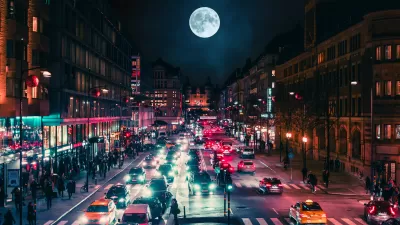 View of busy street at night with full moon in background in Stockholm, Sweden