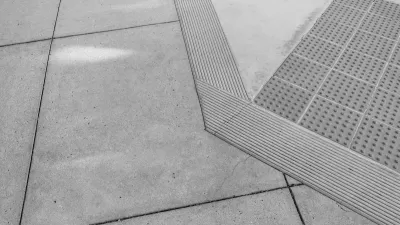 Grey concrete curb ramp with small bumps for the visually impaired.