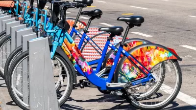 Bay Wheels bike share station full of colorful parked bikes on San Francisco street.