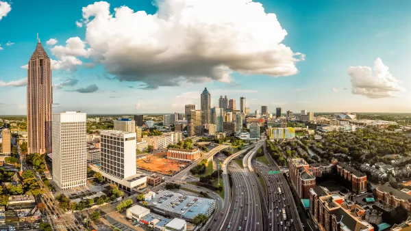Birds-eye view of Atlanta skyline and highway running through the middle of it.