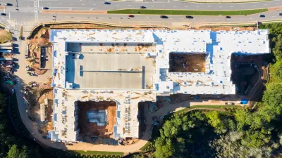 Bird's eye view of large apartment complex under construction next to four-lane road near Atlanta, Georgia.