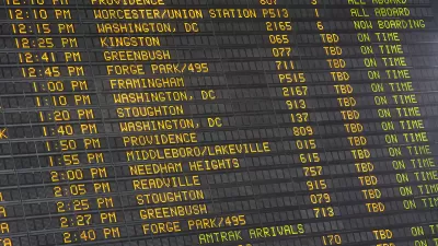 Close-up of old-fashioned trains departure board with yellow text on black background in Boston, Massachusetts train station.