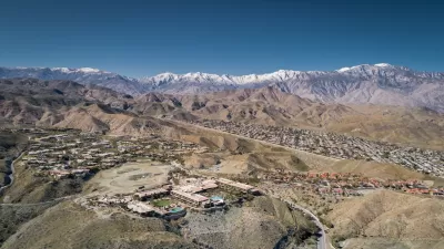 Aerial view of Rancho Mirage, California with homes in foreground and snowy San Gabriel Mountains in background.