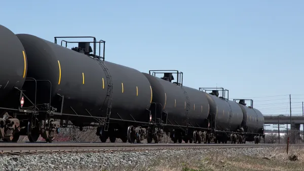 Train with black oil tankers.