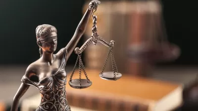 Close-up of bronze symbolic Justice statue of blindfolded woman holding up scales.