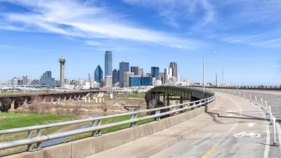 Separated protected bike lane on highway leading toward downtown Dallas, Texas.
