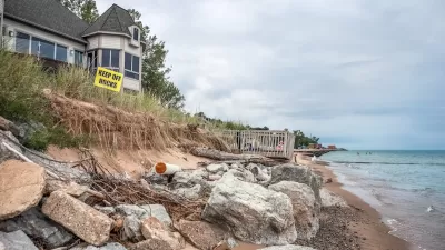 Houses on Lake Michigan shore with yellow "Keep Off Rocks" sign.