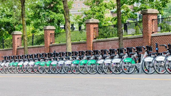 Long row of Bixi bike share bikes parked at station on street in Montreal, Canada.