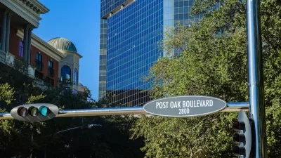 "Post Oak Boulevard" street sign in downtown Houston, Texas with glass high-rises in background.