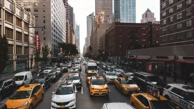 Yellow taxis and white cars in traffic on New York City street.