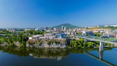Aerial view of Chattanooga, Tennessee with blue bridge over river in foreground.