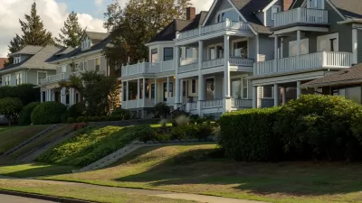 Row of large multistory homes with multilevel porches on the front and a bike lane on the street in front of them.