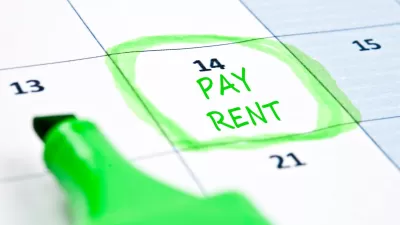 Close-up of calendar with "Pay rent" written on day 14 and circled in green highlighter