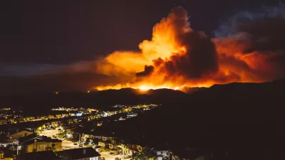 Night view of wildfire burning near residential area in California