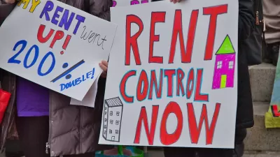 Close-up of "Rent Control Now" sign being held up at a protest.