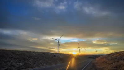 Wind turbines sillhouetted against a sunset sky along roadway in New Mexico