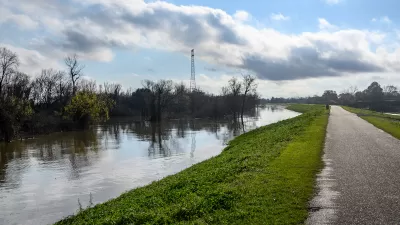 Paved bike path on top of earthen dike levee along Mississippi River in Louisiana.