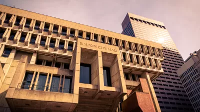 Looking up at modernist/brutalist Boston City Hall building bathed in golden hour light