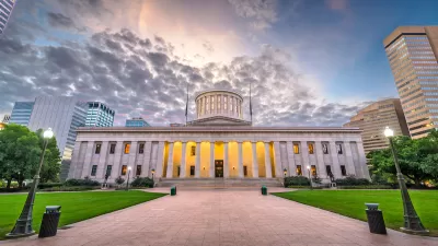 Ohio state capitol dome against dramatic lightly cloudy sky.