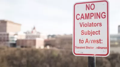 Close-up of red and white "No camping - Violators subject to arrest" sign.