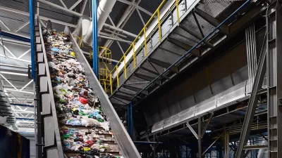 Conveyor belt in industrial recycling center with plastic materials.