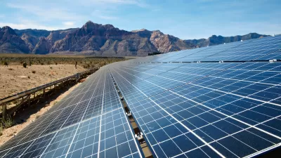Solar panel array with Mojave Desert mountains in background.