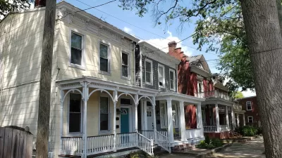 Historic homes with intricate white trim on tree-lined street in Richmond, Virginia.