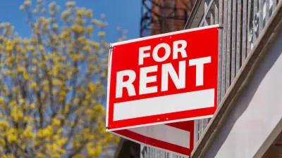 Close-up on red and white "For Rent" sign on building.